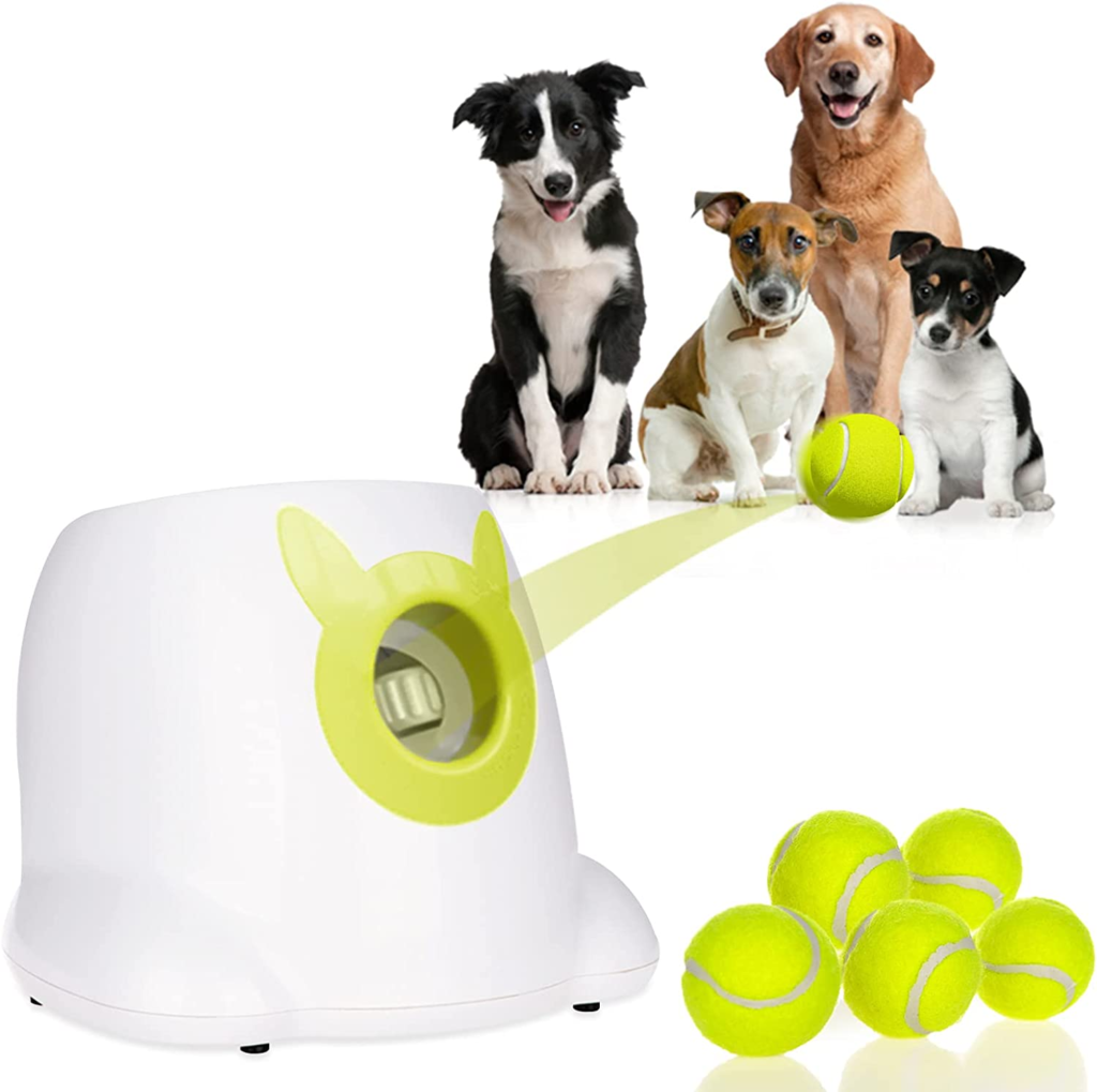 Automatic ball launcher toy pictured throwing a yellow tennis ball to a group of dogs